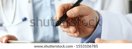 Male GP making electronic notes in tablet pc closeup