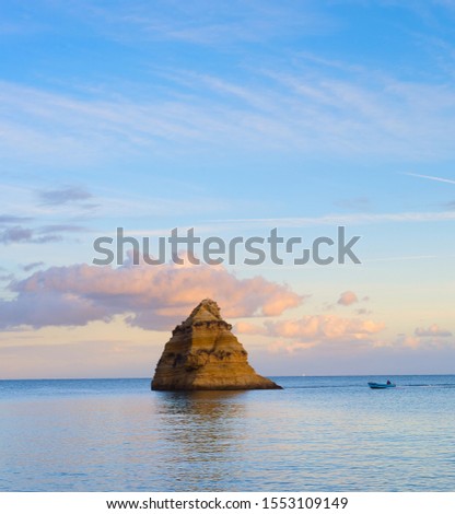 Landscape with the ocean, fisher and a cliff at sunset. Lagos,Algarve, Portgual
