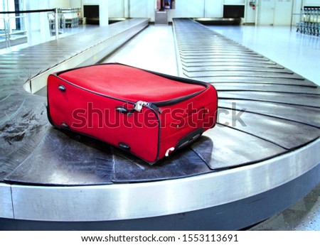 Red case forgotten on an airport conveyor Royalty-Free Stock Photo #1553113691