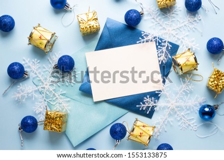snowflakes with card invitation and envelope on blue. Christmas and new year tree balls and decor