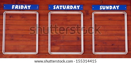 Sign board on a wooden wall with empty space for activities on friday, saterday and sunday 