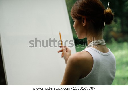 young woman draws on white canvas