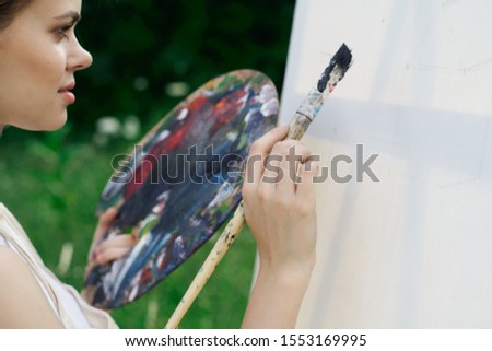 young woman draws on white canvas