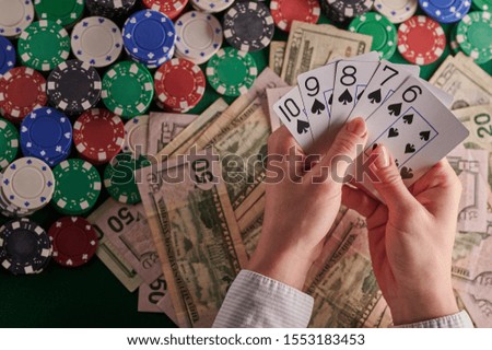 a poker player in a casino, a combination of straight flush cards, a lot of money and chips. horizontal frame. casino background