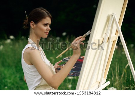 woman paints a picture on white canvas