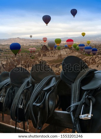 Cappadocia balloon tour at sunrise. Rider Leather Saddles equestrian with stirrups on fence. Cappadocia, Anatolia, ballooning Turkey. Open air museum, Goreme national park.
