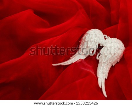 white glitter wings on red background