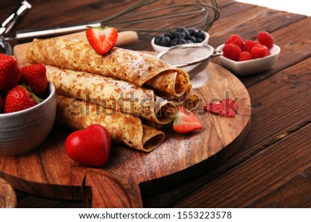 Delicious Tasty Homemade crepes or pancakes with raspberries and mint on table