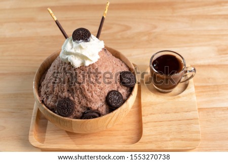 Bingsu or chocolate clear ice in a wooden cup with chocolate sauce