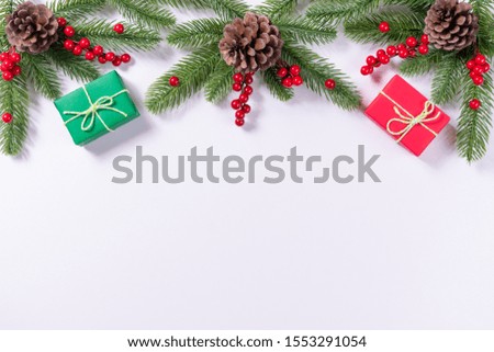 Christmas composition. Gifts, fir tree branches, red berries on white background. Christmas, winter, new year concept.