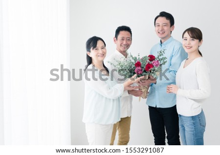 Newlyweds giving flowers to their parents