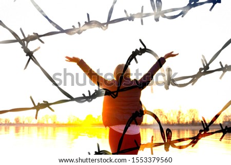 Barbed wire on fence on blue sky background