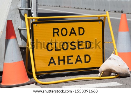 Road closed ahead sign in a city street.