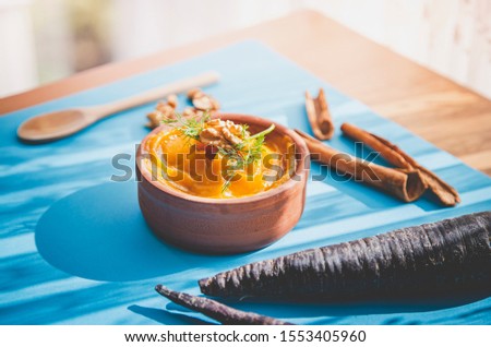 Pumpkin puree with wooden spoon and cinnamon sticks natural day light image