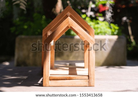 Wood home symbol for dream house with sunshine in the garden