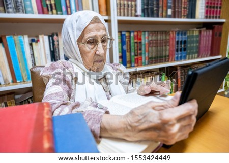 Arabic muslim woman using laptop for reading E-books nad surfing internet