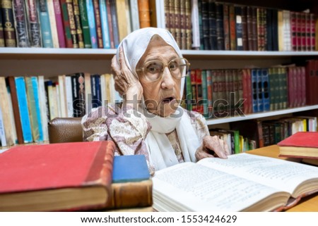 Arabic muslim woman supervising library and asking people to keep quiet