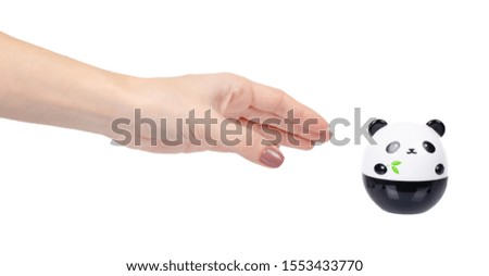 Hand with face cream in plastic panda container. Isolated on white background.