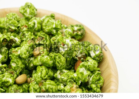 Lush of Japanese matcha green tea popcorn in the wooden bowl bulk isolated on white background, Popular snack with favorite movie