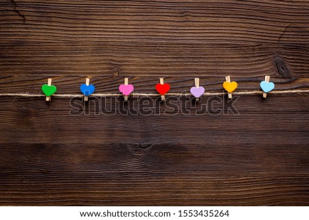 Garland with heart icons on dark wooden background top view space for text
