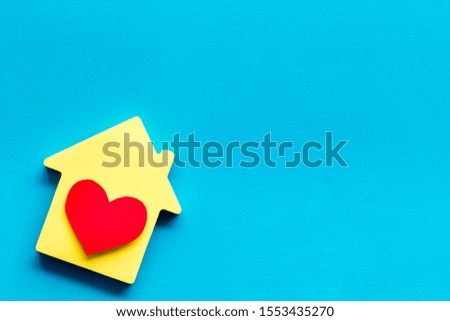 Happy life and home concept. House cutout and heart icon on blue background top view space for text