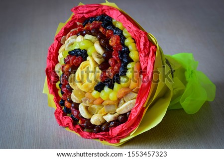 The original bouquet of dried fruits, lying on a gray background. An amazing gift for all occasions. Royalty-Free Stock Photo #1553457323