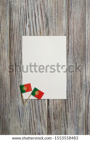 December 1, happy independence day of Portugal. day of patriotism, faith, freedom. Mini flags on wooden background with white sheet of paper.