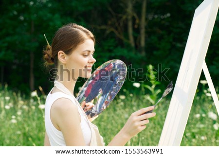 woman in the open air draws a picture on canvas