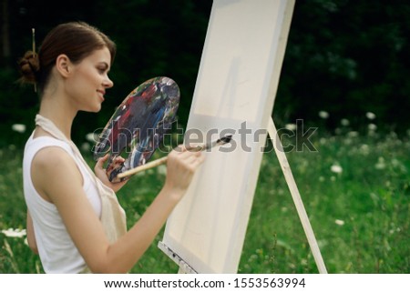woman in the open air draws a picture on canvas