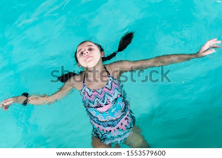 Beautiful girl swim and having fun in water.Active holiday.Girl swim in the pool. Happy girl play in the pool.