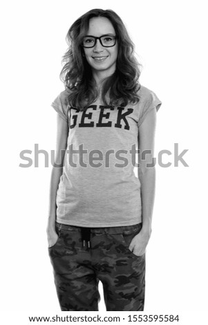Studio shot of happy geek girl smiling and standing while wearing eyeglasses