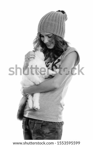 Studio shot of happy geek girl smiling while holding cute cat
