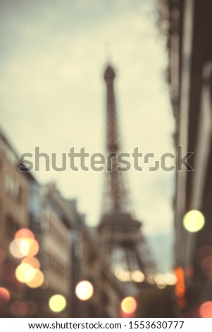Blurred image of Eiffel Tower in Paris at night with street lights.