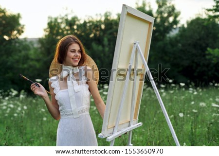 young woman with straw hat easel