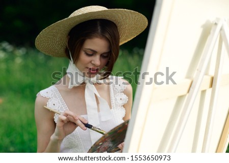 young woman with straw hat easel