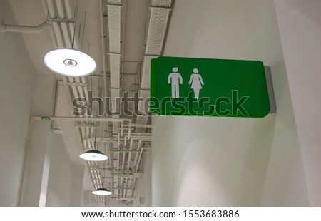 Designation of a public toilet room with signs for men and women in the form of white human symbols on a bright green background