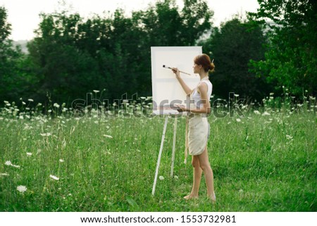 young woman on a forest glade easel with canvas