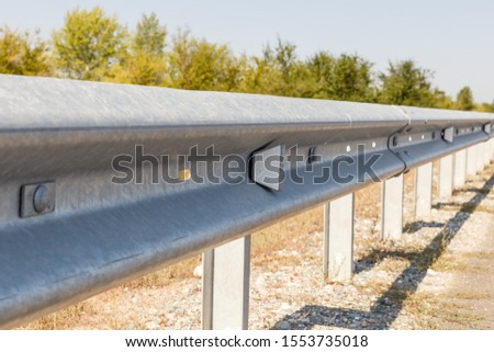 white road reflectors along the road. metal road fencing of barrier type, close-up. Road and traffic safety