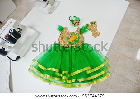 Children's carnival hand made girl costume at seamstress office on workplace.