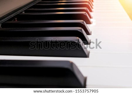 Close-up shot of classic piano keyboard with sunlight effect