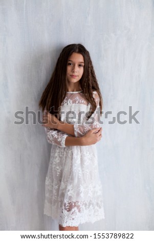 Beautiful fashionable girl at school in white dress