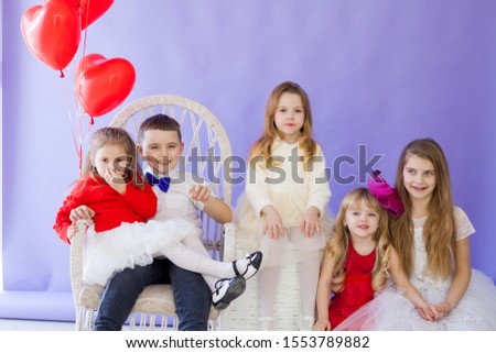 Boy and girls with red heart-shaped balloons on birthday party