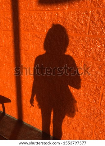 Teen shadow on pretty orange wall 