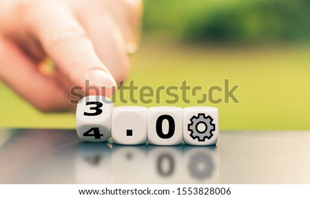 Hand is turning a dice and changes the expression "Industry 3.0" to "Industry 4.0"	 Royalty-Free Stock Photo #1553828006