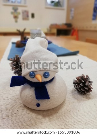 Handmade snowman with blue eyes and a blue scarf.