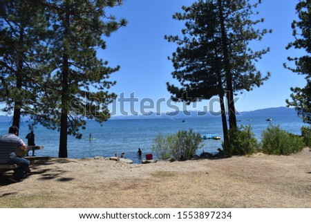 Beautiful landscape picture of Lake Tahoe. Water view with view of mountains and ski slopes in summer. 