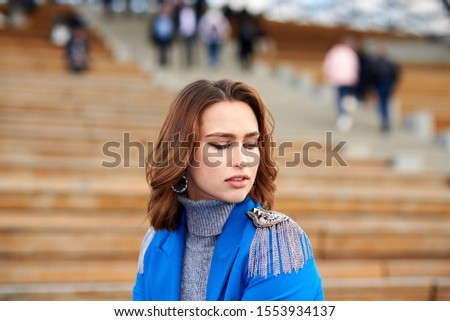 Young pretty woman in a blue suit walking and posing in a center of Moscow city