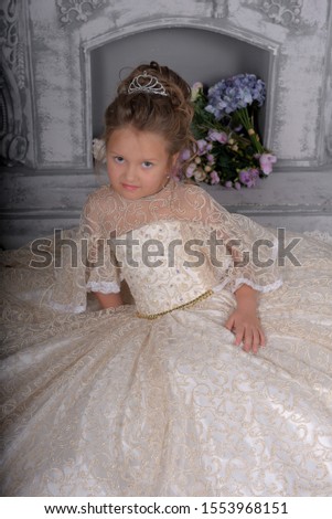 cute little girl in elegant white Victorian dress in the interior