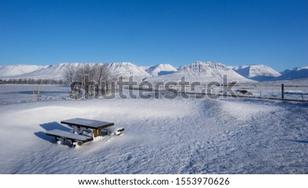 Frozen picnic bench covered in snow. Iceland.