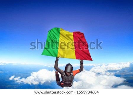 Mali flag. Flag in skydiving. People in free fall grab flag of Mali. Patriotism, men and flag.
